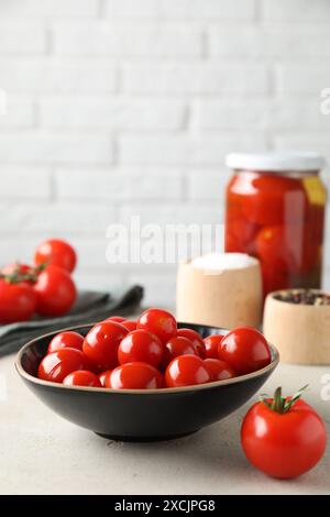 Gustosi pomodori sottaceto, verdure fresche e spezie su un tavolo grigio chiaro Foto Stock