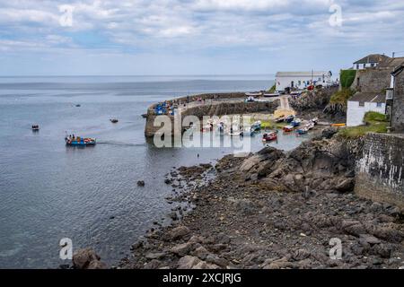 L'affascinante piccolo villaggio di pescatori di Coverack sulla costa meridionale della Cornovaglia, in Inghilterra. Barche da pesca ormeggiate nel piccolo porto con la bassa marea. Foto Stock