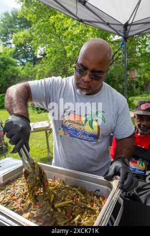 Detroit, Michigan - Xaviar Jaramillo serve assaggi della sua cucina al Collard Green Cook-Off, una competizione per i migliori chef verdi del collard Foto Stock