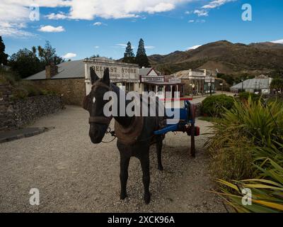 Cromwell, nuova Zelanda - 2024: Statua del cavallo di fronte ai vecchi edifici storici antichi, la strada della facciata dei panifici nel quartiere storico di Cromwell nel centro Foto Stock