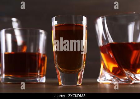 Diversi deliziosi liquori in bicchieri su un tavolo di legno Foto Stock