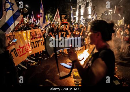 Gerusalemme, Israele. 17 giugno 2024. Ayala Metzger canta con l'altoparlante di carico come manifestanti segni d'onda e bandiera israeliana durante una manifestazione a Gerusalemme, lunedì 17 giugno 2024. I manifestanti anti-governativi israeliani si sono riuniti a Gerusalemme lunedì, alcuni si sono scontrati con la polizia vicino alla casa del primo ministro Benjamin Netanyahu chiedendo nuove elezioni e un accordo con Hamas in ostaggio. Crediti: Eyal Warshavsky/Alamy Live News Foto Stock