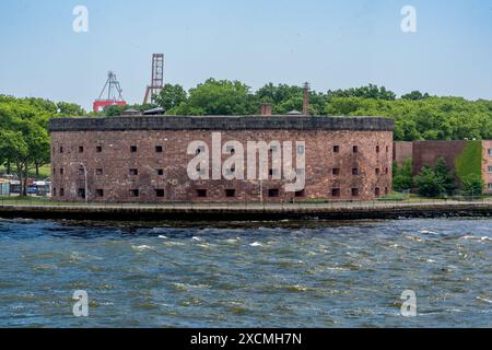 New York, New York – Stati Uniti – 7 giugno 2024 Castle Williams, un impressionante forte circolare in arenaria rossa, attira l'attenzione sul punto nord-ovest di Governors Island, A. Foto Stock