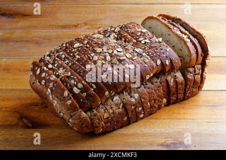 Pane integrale di frumento o pane integrale con grani e semi affettati su un tavolo di legno. Vista dall'alto Foto Stock