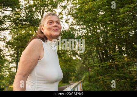 Una donna anziana sorridente a piedi Foto Stock