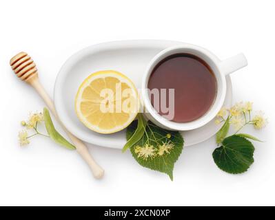 Tazza di tè al tiglio con cucchiaio di limone e miele su sfondo bianco Foto Stock