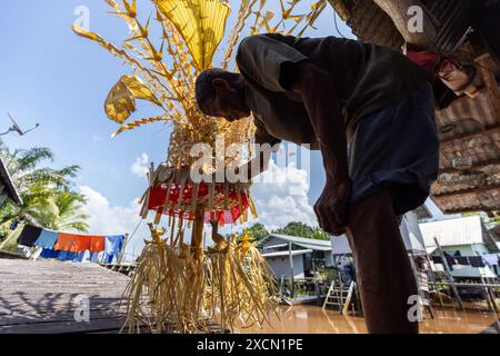 Un uomo prepara oggetti di scena tradizionali per il rituale Melanau serahang durante il Kaul Festival Foto Stock