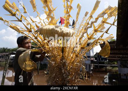 Un uomo prepara oggetti di scena tradizionali per il rituale Melanau serahang durante il Kaul Festival Foto Stock