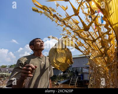 Un uomo prepara oggetti di scena tradizionali per il rituale Melanau serahang durante il Kaul Festival Foto Stock