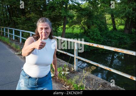 Una donna più anziana regala un pollice Foto Stock