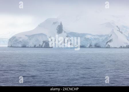 Montagne sull'isola di Anversa coperte di neve fitta e ricoperte da una fitta nebbia Foto Stock