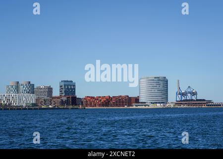 Edificio circolare per uffici Spidsen, (sulla destra) progettato da Vilhelm Lauritzen Architects, su Nordø/Redmolen, Portland Towers (a destra) Copenhagen Foto Stock