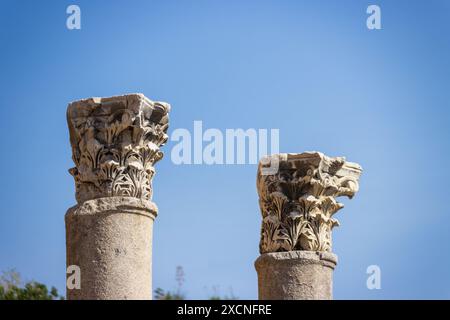 I resti di colonne di pietra scolpite nell'antica città in rovina di Perge vicino ad Antalya in Turchia in una giornata di sole, una classica destinazione turistica di un giorno. Foto Stock