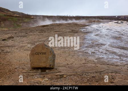 Il grande Geysir nell'area geotermica dell'Islanda, una piscina di sorgenti termali di geyser fumante con cartello "Geysir". Foto Stock