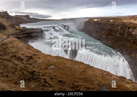 Cascata Gullfoss in Islanda, vista delle cascate con spruzzi d'acqua, canyon coperto di muschio, maggio, primavera. Foto Stock