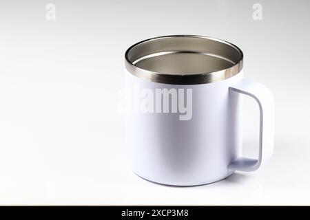 Primo piano smalto bianco all'esterno con tazza interna in acciaio inox, tazza in metallo isolata su sfondo bianco. Foto Stock