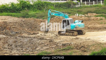 Trapano a terra, trapano pneumatico, lavori da escavatore in cantiere. Foto Stock