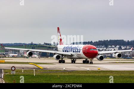 Un Airbus A340-313X operato da Edelweiss Air taxi sulla pista dell'aeroporto di Zurigo, dove è in attesa di autorizzazione al decollo. Registrazione HB-JM Foto Stock