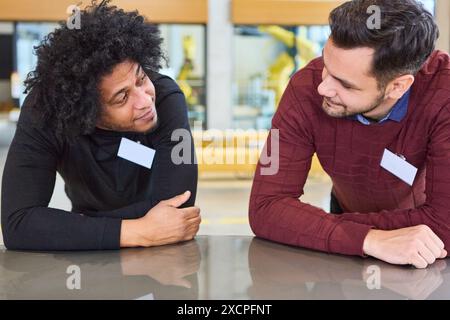 Due professionisti si sono impegnati in una discussione durante una sessione di formazione sulla robotica e l'automazione. Foto Stock