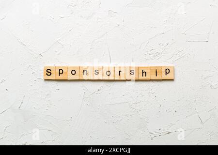 Sponsorizzazione parola scritta sul blocco di legno. La sponsorizzazione del testo in tabella, concetto. Foto Stock