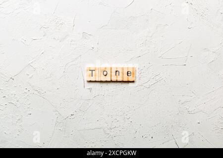 tono parola scritta su blocco di legno. tono testo su tabella di cemento per il vostro desing, concetto. Foto Stock