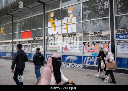 Le persone che passavano i graffiti coprirono WEH Whitechapel Enterprise Hub il 12 giugno 2024 a Londra, Regno Unito. Foto Stock