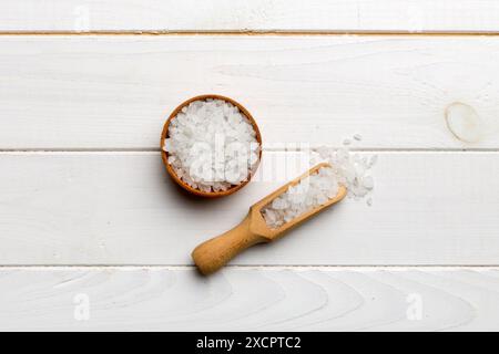 Una ciotola di legno di cristalli di sale su sfondo di legno. Sale in ciotole rustiche, vista dall'alto con spazio copia. Foto Stock