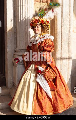 Carnevale di Venezia, felice donna sorridente in costume storico, completo al tramonto a Palazzo dei Dogi, Venezia, Veneto, Italia Foto Stock