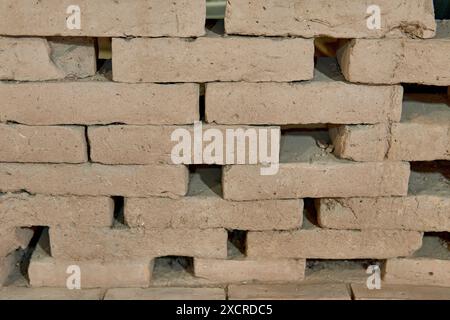 muro di mattoni di fango appoggiati uno contro l'altro, uno sull'altro Foto Stock