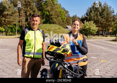 Un uomo e una donna sono in piedi accanto a una moto Foto Stock