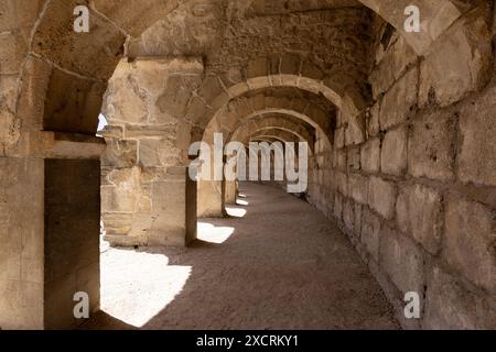 Le colonne della passerella dell'atrio in cima all'antico teatro di Aspendos vicino ad Antalya in Turchia in una giornata di sole, una classica gita turistica di un giorno. Foto Stock