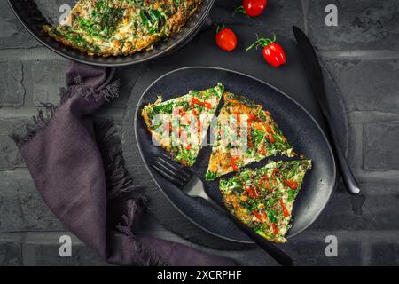 Quiche di spinaci, omelette o frittata con formaggio, uova ed erbe aromatiche Foto Stock