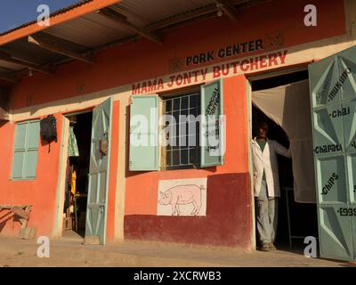 Macellaio in piedi all'ingresso della sua macelleria di maiale vicino a Nanyuki in Kenya Foto Stock