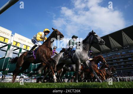 Corridori e cavalieri lasciano le bancarelle all'inizio del Copper Horse handicap il primo giorno del Royal Ascot all'ippodromo di Ascot, Berkshire. Data foto: Martedì 18 giugno 2024. Foto Stock