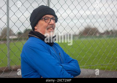 Un uomo anziano va a fare sport, corre all'aria aperta con l'abbigliamento sportivo Foto Stock