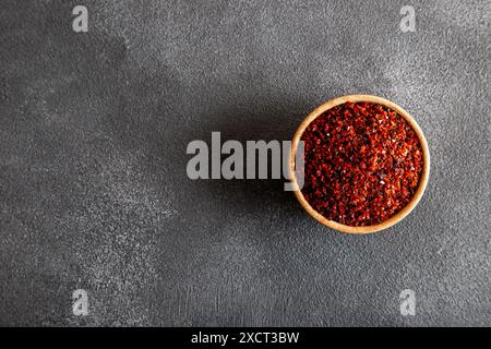 Peperoncino rosso. Peperoncini rossi in un recipiente di legno su sfondo grigio Foto Stock