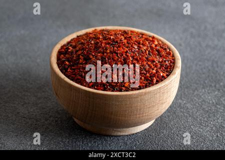 Peperoncino rosso. Peperoncini rossi in un recipiente di legno su sfondo grigio Foto Stock