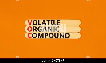 Simbolo del composto organico volatile VOC. Parole concettuali composti organici volatili VOC su un bellissimo bastoncino di legno. Bellissimo sfondo arancione. COV. Business Foto Stock