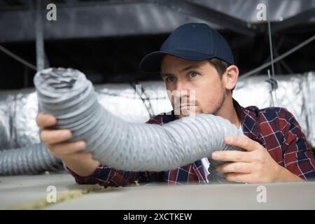 operatore che tiene il tubo flessibile di ventilazione Foto Stock