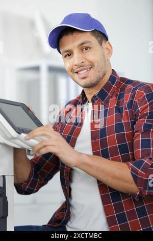 uomo durante la manutenzione, ripara la stampante Foto Stock