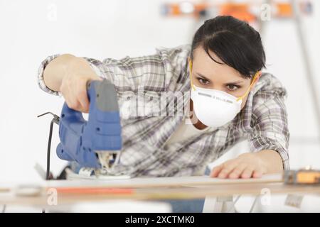 donna che taglia mobili in officina Foto Stock