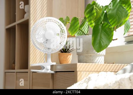 Ventilatore elettrico su Commode nel soggiorno Foto Stock