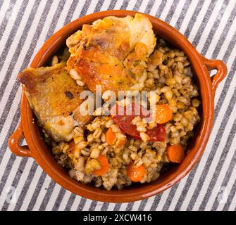 Cosce di pollo con porridge di orzo in pentola di argilla Foto Stock