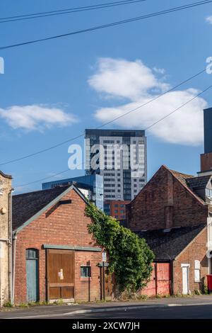 Southampton - Vista da Albert Road che si affaccia sui vecchi negozi di lavoro verso la Moresby Tower presso il porticciolo di Ocean Village, Southampton, Hampshire Inghilterra, Regno Unito Foto Stock