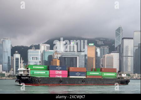 Hong Kong, Cina. 29 aprile 2024. Una nave da carico che trasporta container naviga attraverso il Victoria Harbour mentre lo skyline di Hong Kong viene visto sullo sfondo. Credito: SOPA Images Limited/Alamy Live News Foto Stock