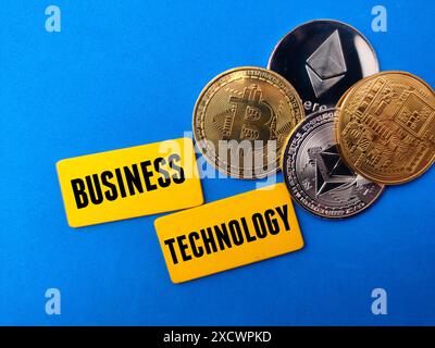 Vista dall'alto btc dorato e eth argento e bacheca colorata con TECNOLOGIA text BUSINESS su sfondo blu. Foto Stock