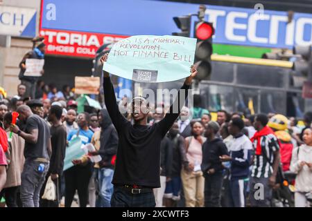 Nairobi, Kenya. 18 giugno 2024. Un manifestante tiene un cartello durante una protesta per opporsi a una proposta di legge finanziaria 2024. I manifestanti hanno definito il disegno di legge punitivo a causa delle nuove tasse elevate proposte che vedranno l'aumento del costo della vita che è già elevato. La protesta soprannominata "Occupy Parliament” coincise con la presentazione del progetto di legge al parlamento keniota. La votazione sulla proposta di legge dovrebbe svolgersi il 20 giugno 2024. Credito: SOPA Images Limited/Alamy Live News Foto Stock