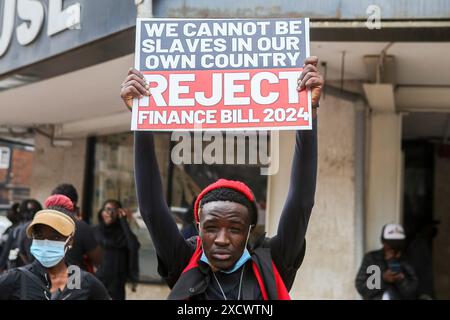 Nairobi, Kenya. 18 giugno 2024. Un manifestante tiene un cartello durante una protesta per opporsi a una proposta di legge finanziaria 2024. I manifestanti hanno definito il disegno di legge punitivo a causa delle nuove tasse elevate proposte che vedranno l'aumento del costo della vita che è già elevato. La protesta soprannominata "Occupy Parliament” coincise con la presentazione del progetto di legge al parlamento keniota. La votazione sulla proposta di legge dovrebbe svolgersi il 20 giugno 2024. (Foto di Boniface Muthoni/SOPA Images/Sipa USA) credito: SIPA USA/Alamy Live News Foto Stock