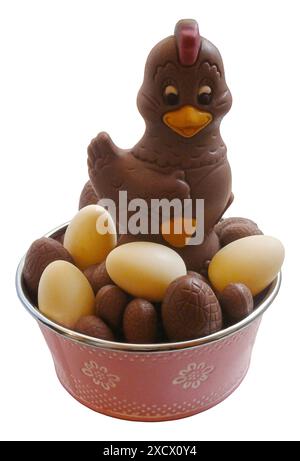 Una foto di una gallina al cioccolato che cosparge le sue uova di pasqua isolate su sfondo bianco Foto Stock