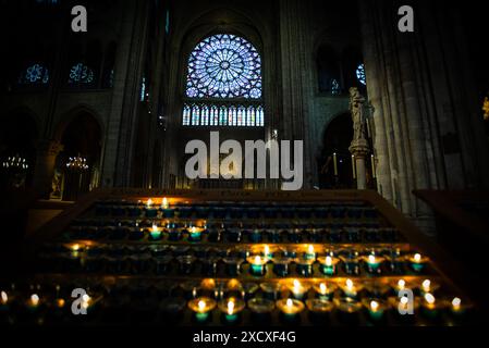 Candele votive e finestra delle rose nella cattedrale di Notre Dame - Parigi, Francia Foto Stock